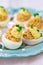 Delicious stuffed eggs on blue plate.