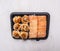 Delicious sushi fast food in a black container wooden rustic background top view close up