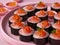 Delicious Sushi Plate with Salmon Nigiri and Fish Roe on Elegant Pink Background, Japanese Cuisine