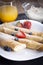 Delicious sweet rolled pancakes on a plate with fresh fruits