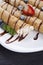 Delicious sweet rolled pancakes on a plate with fresh fruits