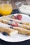 Delicious sweet rolled pancakes on a plate with fresh fruits