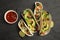 Delicious tacos, lime and sauce on black table, flat lay