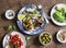 Delicious tapas - sandwiches sardines, mussels, octopus, grape, olives, tomato and avocado on wooden table, top view.