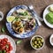 Delicious tapas - sandwiches with sardines, mussels, octopus, grape, tomato and avocado on wooden table
