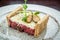 Delicious tartare with toasted bread and salad on a plate. Healthy lunch meal made of raw meat.