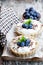 Delicious tarts with cream and fresh blueberry on wooden table