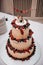 Delicious three-tiered cake topped with fresh berry and intricate decorations