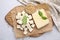 Delicious tofu cheese, basil and soybeans on light gray table, flat lay