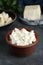 Delicious tofu cream cheese in bowl on black table, closeup