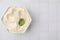 Delicious tofu sauce and basil leaf in bowl on white tiled table, top view. Space for text