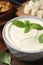 Delicious tofu sauce and basil leaves in bowl on table