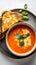 Delicious tomato soup with cream olive oil and fresh basil. Grilled cheese sandwich on a side. Nutritious food