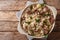 Delicious traditional Estonian mulgikapsas stewed pork with sauerkraut and barley close-up in a pan on the table. Horizontal top