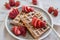 Delicious vanilla waffles with strawberry on table