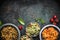 Delicious various vegetarian salads in bowls on dark rustic background, top view, border. Healthy eating