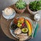 Delicious vegan Food Plate with Cappuccino next to Plants on fancy wooden Table