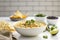 Delicious vegan queso dip on a white table, perfect for dipping chips or veggies