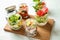 Delicious vegetable salads with chicken in mason jars on wooden board