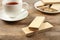 Delicious wafers with cup of tea on brown  background