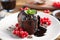 Delicious warm chocolate lava cake with mint and berries on plate
