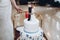 Delicious wedding cake with blue flowers and figurines on top, bride and groom tied forever concept at wedding reception in