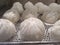 Delicious white loaf of steamed buns on the stainless shelf in the steam