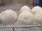 Delicious white loaf of steamed buns on the stainless shelf in the steam