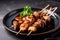 Delicious yakitori skewers with charred edges and succulent chicken meat, served on a traditional Japanese plate