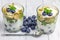 Delicious yogurt dessert with blueberry, kiwi and cereals in glass