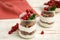 Delicious yogurt parfait with fresh red currants and mint on white wooden table, closeup