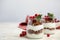 Delicious yogurt parfait with fresh red currants and mint on white wooden table, space for text