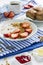 Delicious yogurt topped with sliced strawberries on a plate on a patterned fabric