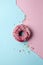 Delicious yummy pink glazed topping doughnut on dual-tone background