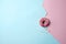 Delicious yummy pink glazed topping doughnut on dual-tone background