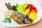 Deliciously baked whole trout with potatoes, tomatoes and greens