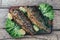 A deliciously roasted carp on a grill, presented on a wooden board, and along the leaves of green salad and pieces of lemon