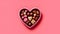 Delight your senses with heart shaped candies in a charming box on a pink background