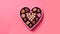 Delight your senses with heart shaped candies in a charming box on a pink background