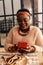 Delighted afro American woman reading a message