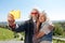 Delighted aged couple taking selfies