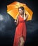 Delighted brunette lady with orange umbrella