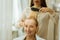 Delighted cheerful woman having her hair brushed