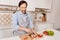 Delighted cook cutting pepper for dinner in the kitchen