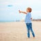 Delighted cute young boy, kid having fun on sandy beach, playing leisure activity games with propeller toy