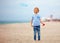 Delighted cute young boy, kid having fun on sandy beach, playing leisure activity games with propeller toy