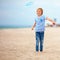 Delighted cute young boy, kid having fun on sandy beach, playing leisure activity games with propeller toy