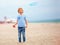 Delighted cute young boy, kid having fun on sandy beach, playing leisure activity games with propeller toy