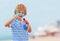 Delighted cute young boy, kid having fun on sandy beach, playing leisure activity games with propeller toy