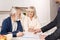 Delighted elderly couple signing agreement at home